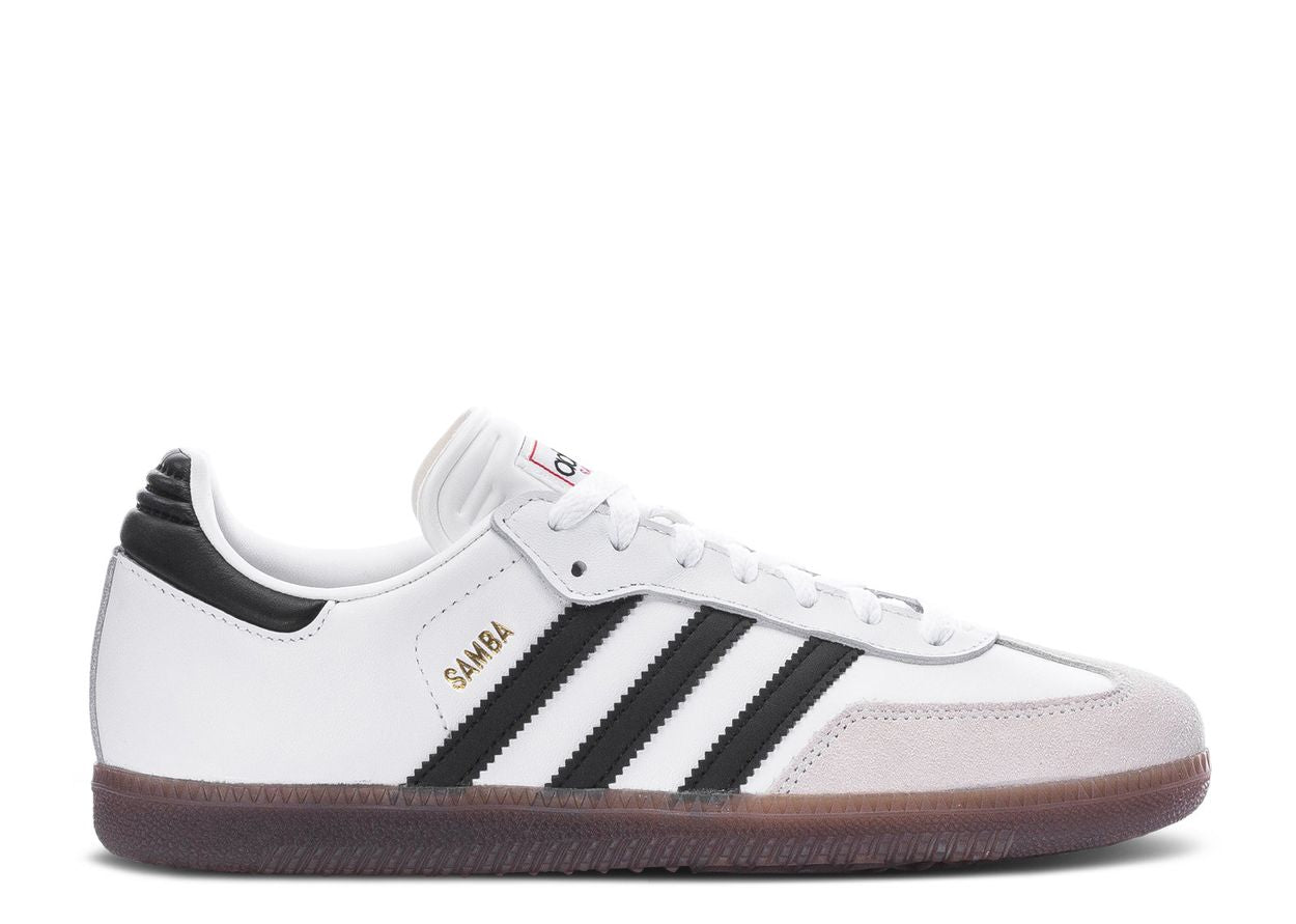 The Adidas Samba White None GS sneaker, style IF1944, features white leather, black stripes and heel patch, suede toe cap, a brown gum sole, and gold SAMBA lettering on the side.