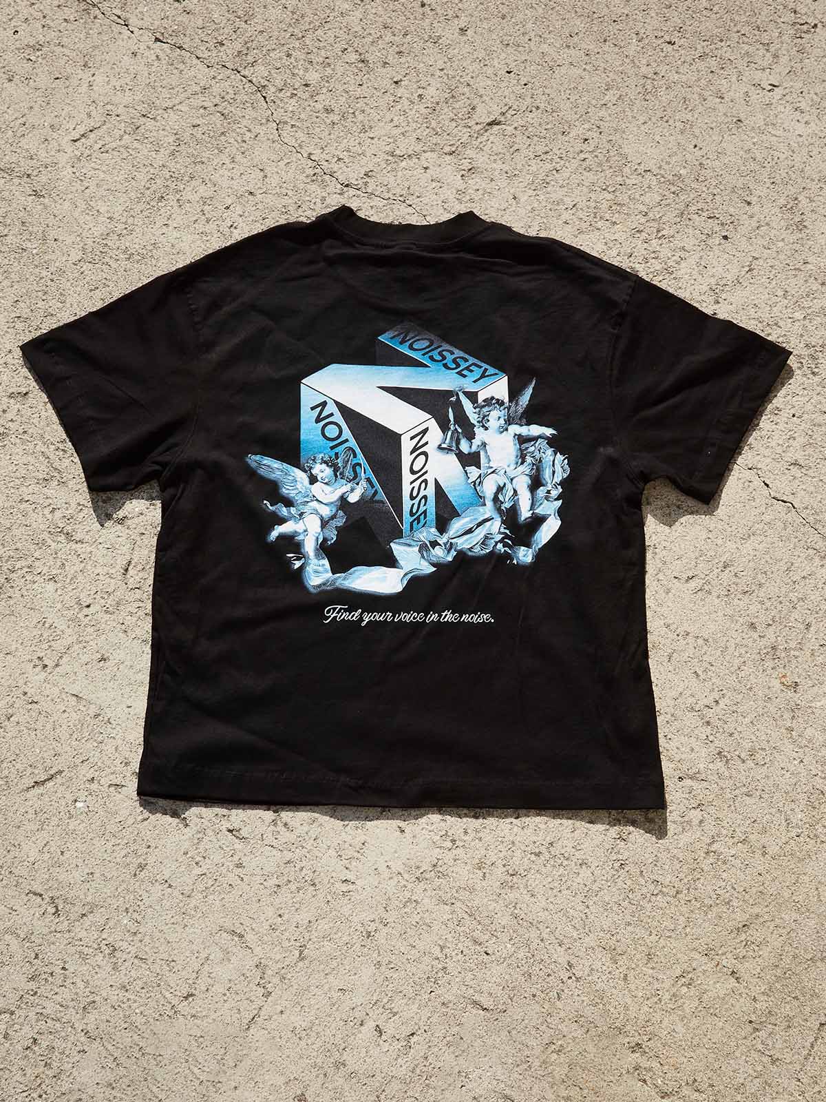 Flat lay of black cotton tee showing the large artistic back print and small minimalist front chest logo.