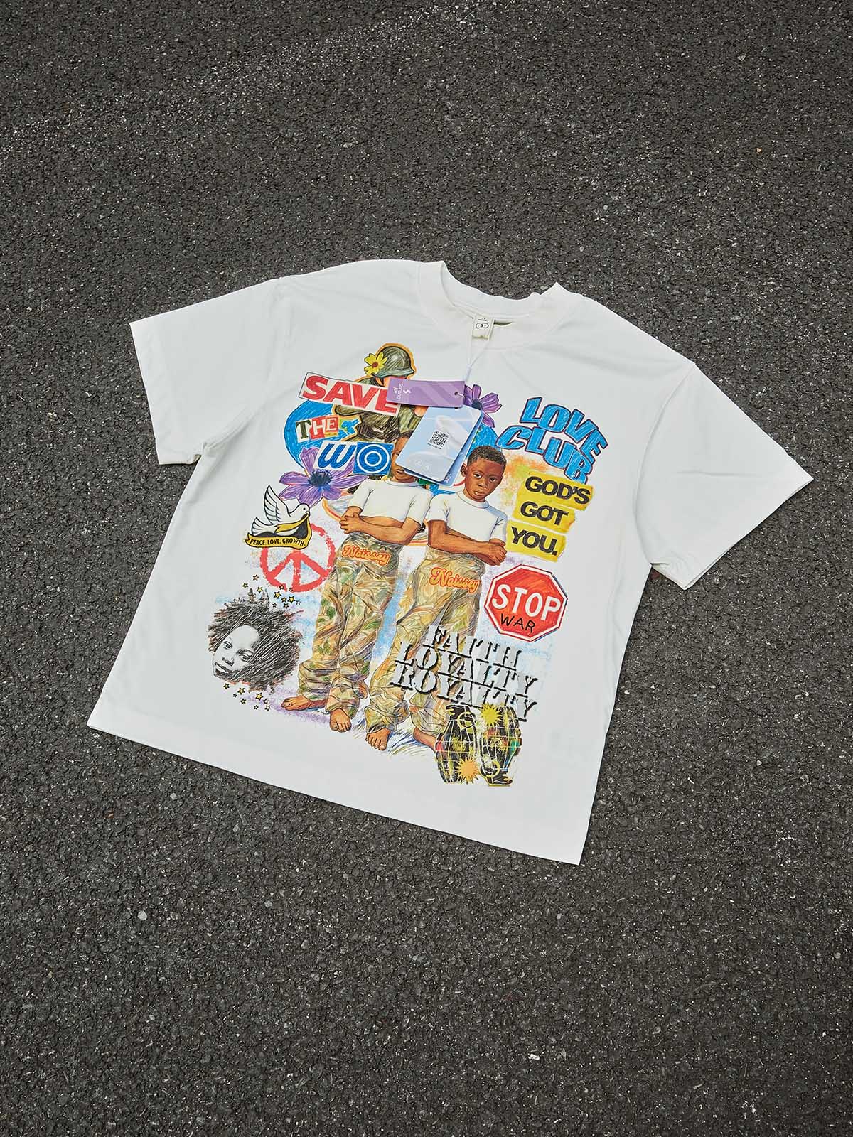Top-down view of the "Faith Loyalty Royalty" graphic tee featuring peace symbols, soldiers, and children in a street-art style.
