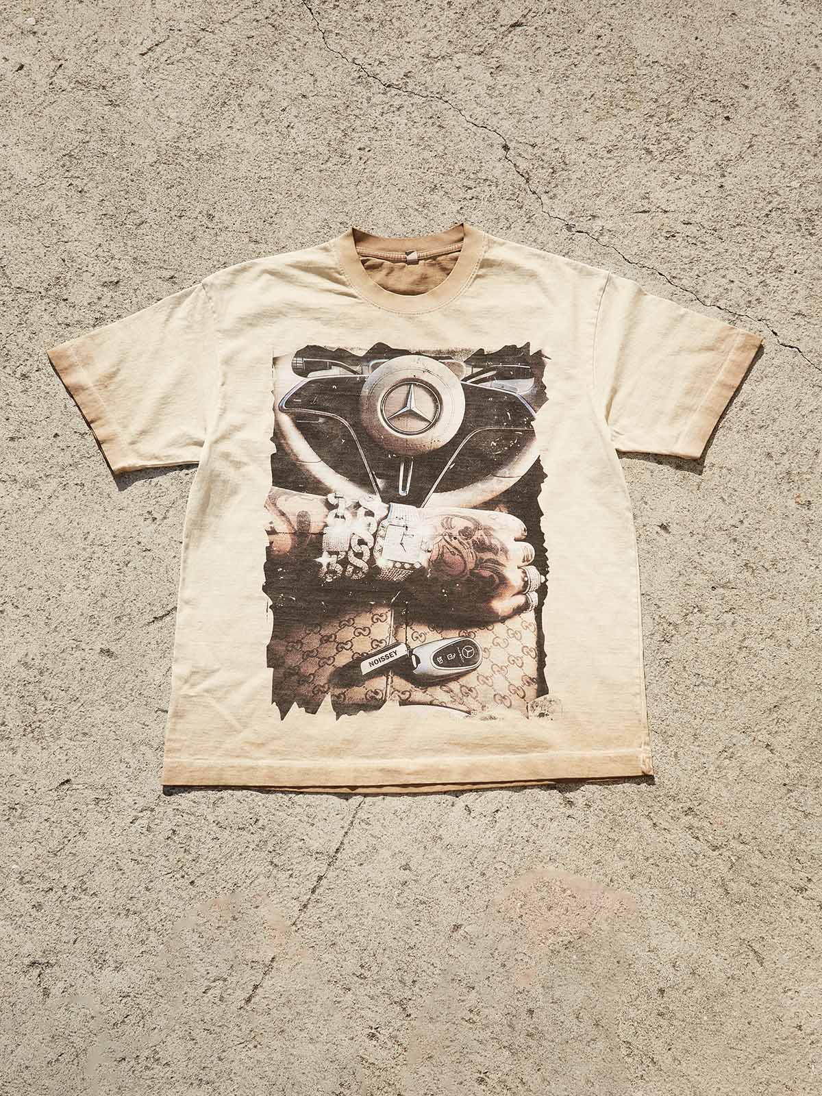 Top-down view of the Instant Luxury tee, showing the distressed graphic edges and the vintage-washed cotton texture.