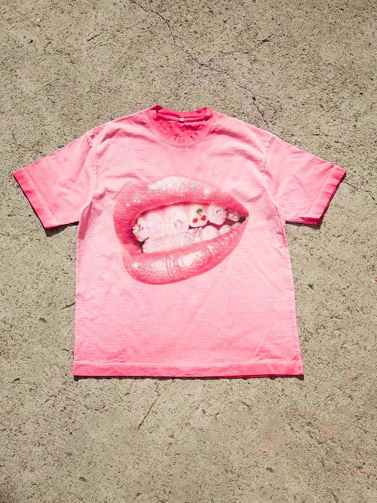 Top-down view of the pink washed streetwear tee showing the vibrant pop-art lip graphic and wide collar detail.