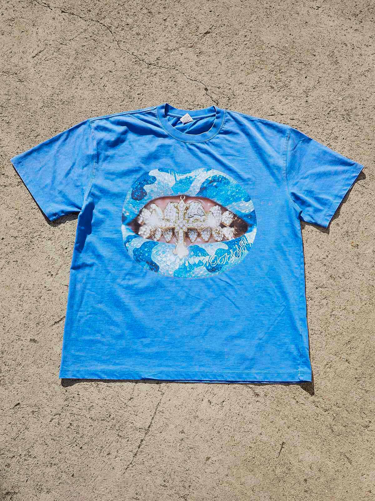 A flat lay of the blue washed oversized t-shirt, showcasing the vibrant graphic print and the vintage texture of the fabric.