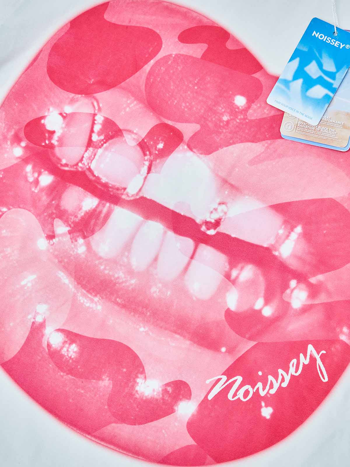 Close-up detail of the lip drill art print and camouflage fabric texture on the pink graphic tee.