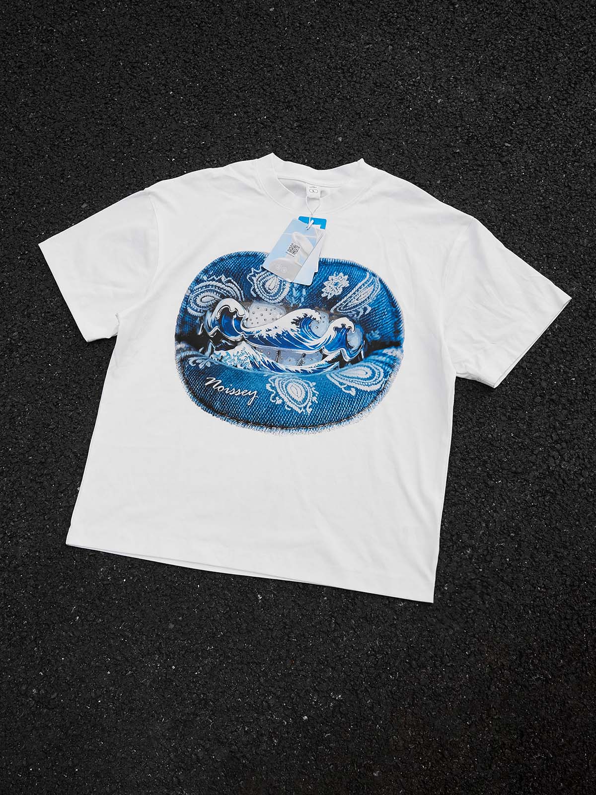 Styled flat lay of the Denim Blue Japanese art tee paired with streetwear accessories on a concrete texture.